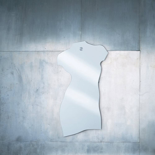 Milo mirror in the shape of the torso of the human body on a gray wall.
