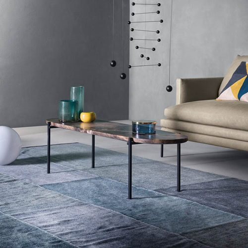 Niobe 671 672 coffee table with round top in brown and white marble, and black slender metal legs in a living room.