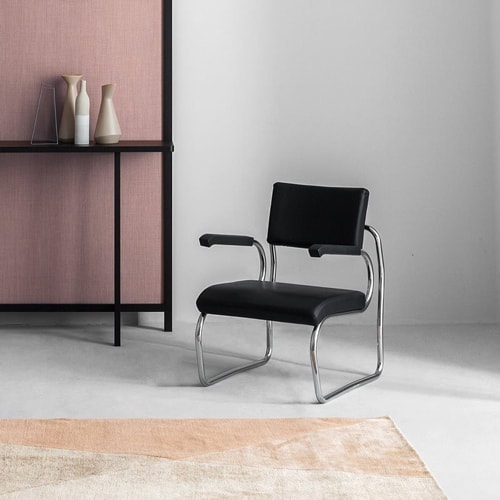 Sant'Elia lounge chair with a modern design, featuring a silve metal frame and black upholstered seat in a living room.
