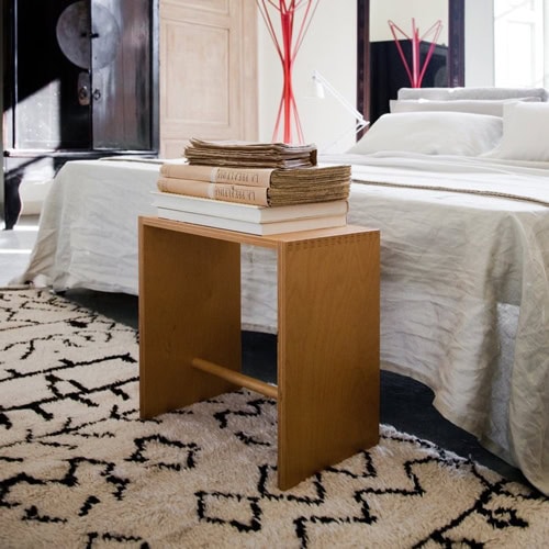 Sgabillo stool with a rectangle wooden frame, in light brown finish in a bedroom.