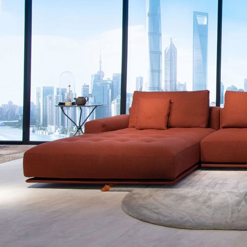 Shiki sofa upholstered in red with cushions in a living room.