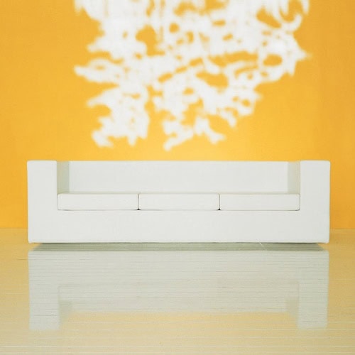 Throw-Away sofa featuring white fabric upholstery and a boxy shape on a yellow background.