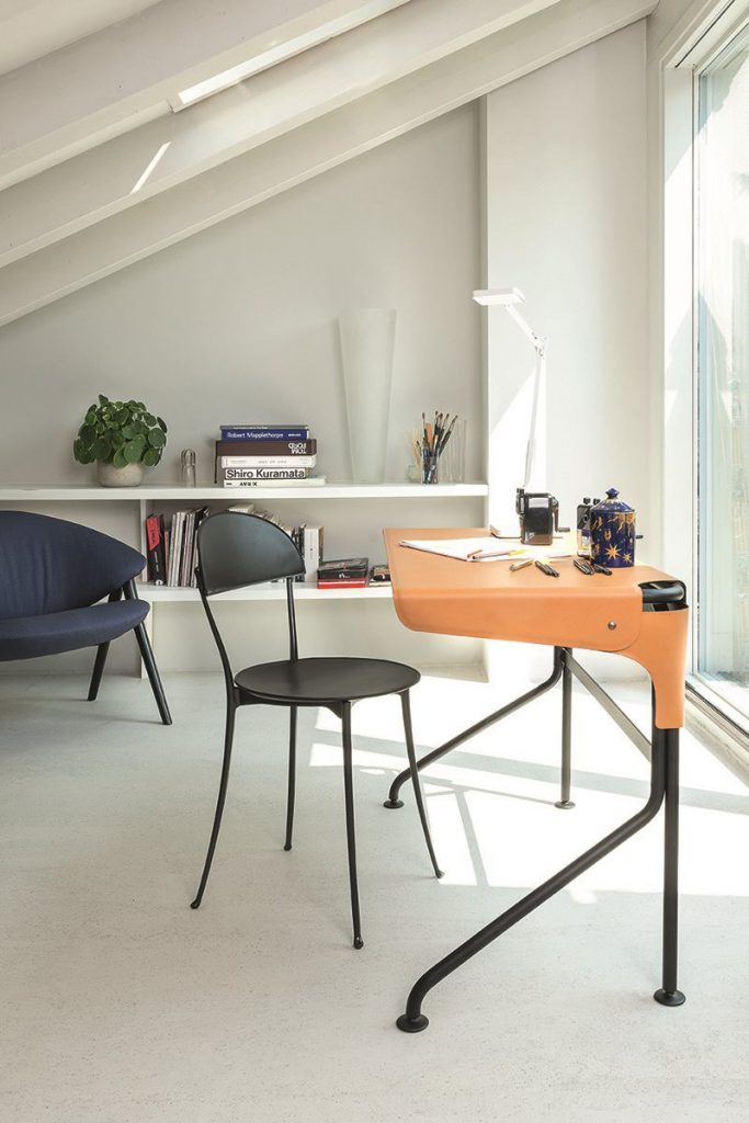 desk made of varnished steel base, top covered in leather in an orange tone