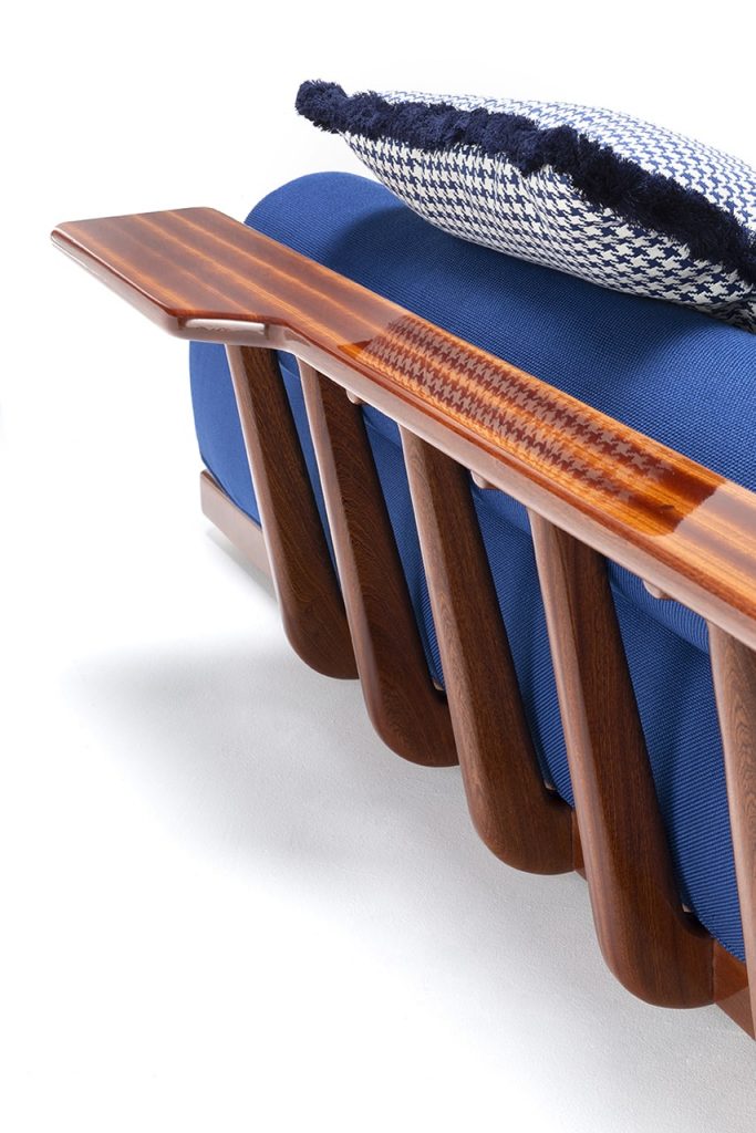 sofa with arm rest in light wood and blue upholstery on a white background