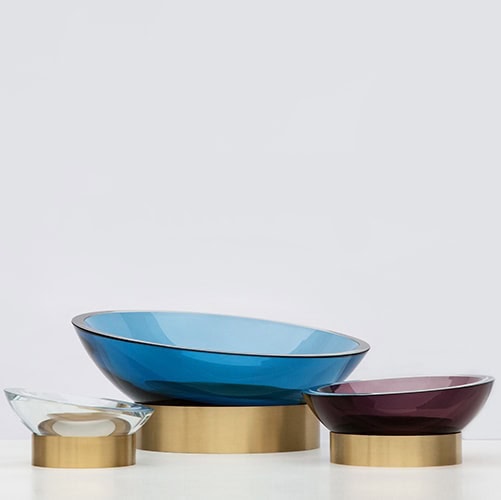 Hand blown glass bowl in purple, blue or clear color on metal ring base on white background