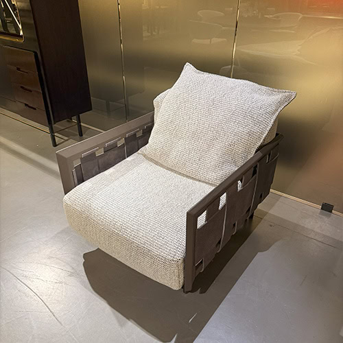 Hen Armchair RF features plush beige upholstery and bold basket-weave side panels, blending laid-back comfort with sculptural character for a modern lounge setting.