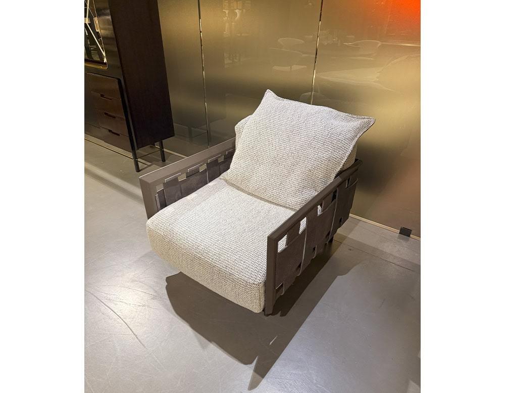 Hen Armchair RF pairs woven leather-like paneling with an oversized seat in a soft beige hue. Its earthy palette and inviting form make it a refined yet relaxed lounge essential.