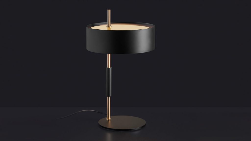 small reading lamp made of gold metal and aluminum composed of a disc at its base and a semisphere at its head
