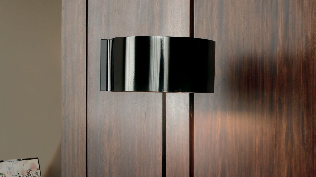 black metal and aluminum reading lamp composed of a disc at its base and a semisphere at its head in a room
