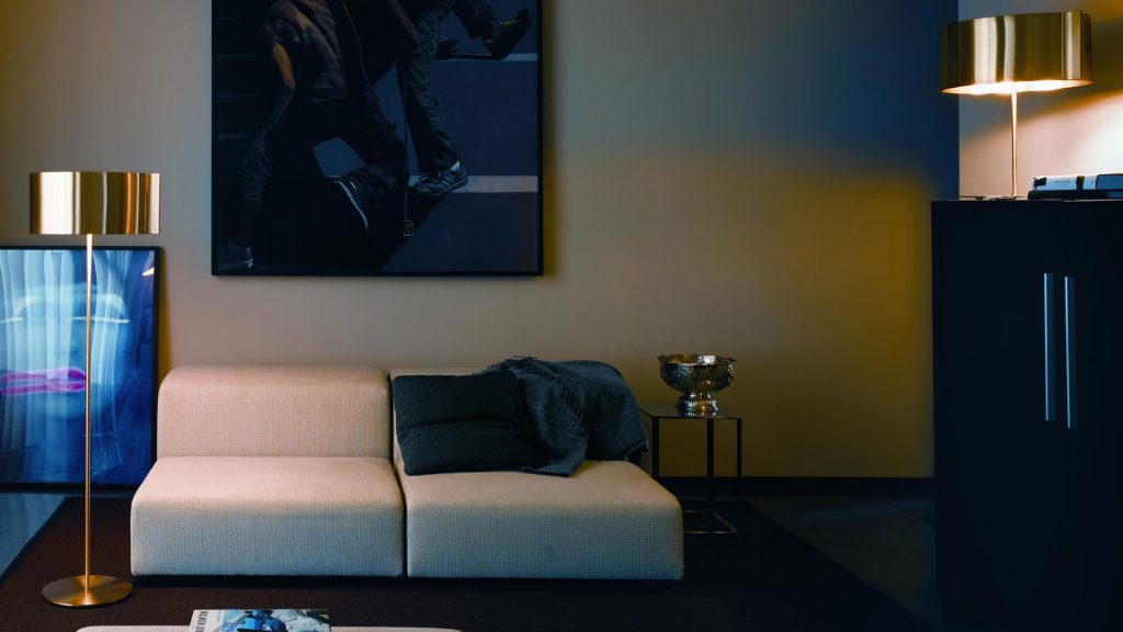 Floor lamp made up of two metal and aluminum discs in black with gold finishes in a living room