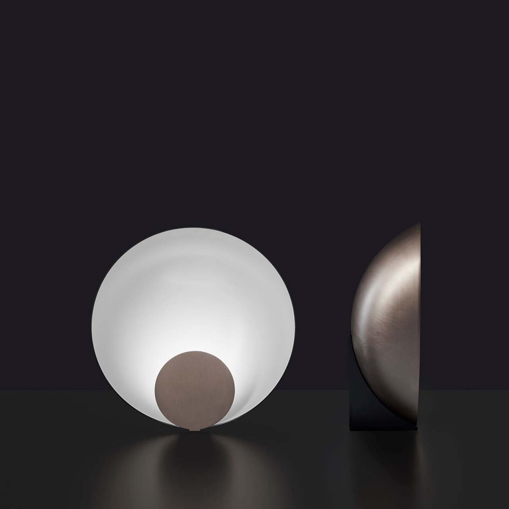 semicircular table lamp made of metal in a white tone with brown finishes on its sides