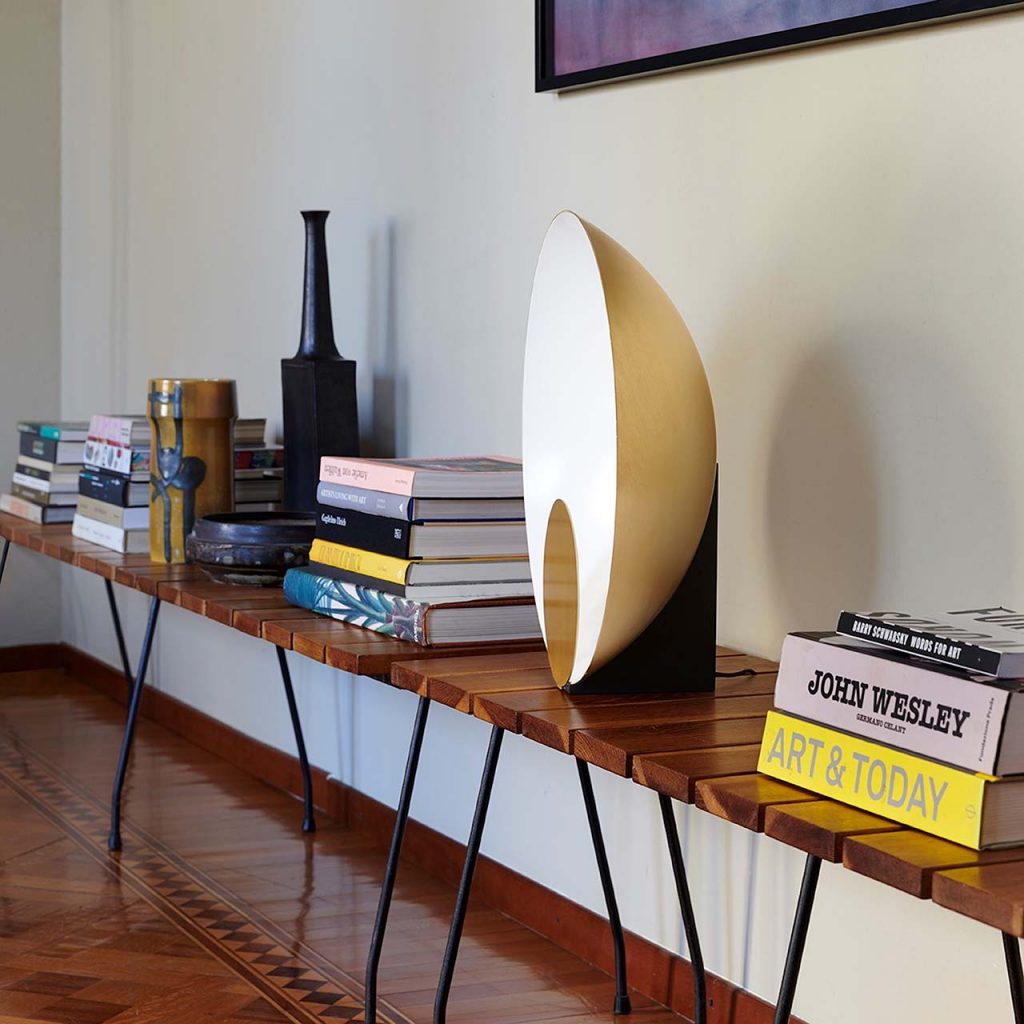 Lamp in the shape of a semicircle on a white metal base with golden finishes on its front disc
