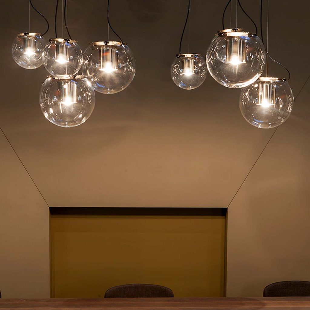 line of hanging lamps made of glass and black metal spheres in a living room