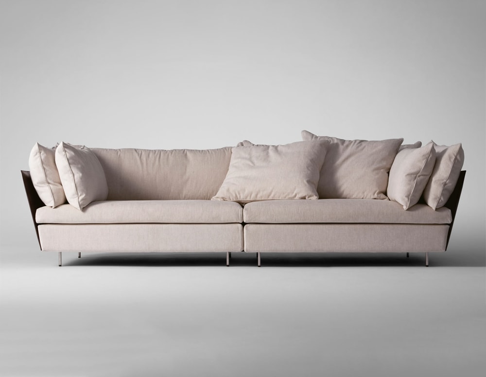 sofa made of steel base and upholstered in thick beige leather with brown finishes in a gray background