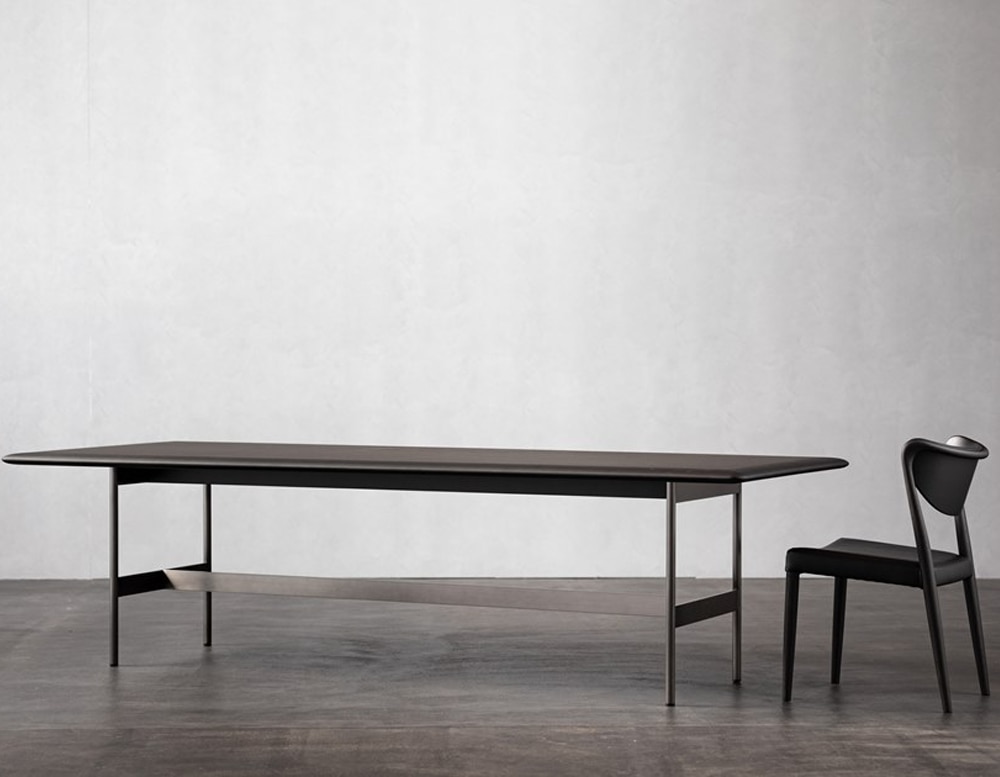 long table made of leather and wood on its base in a dark brown tone on a gray background