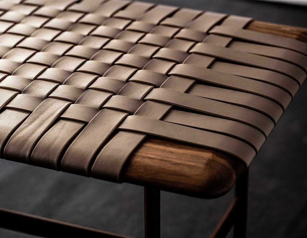 dining table made of strips of brown leather and dark brown wood