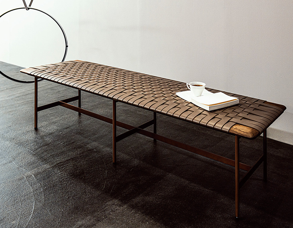 dining table made of strips of brown leather and dark brown wood in an living room