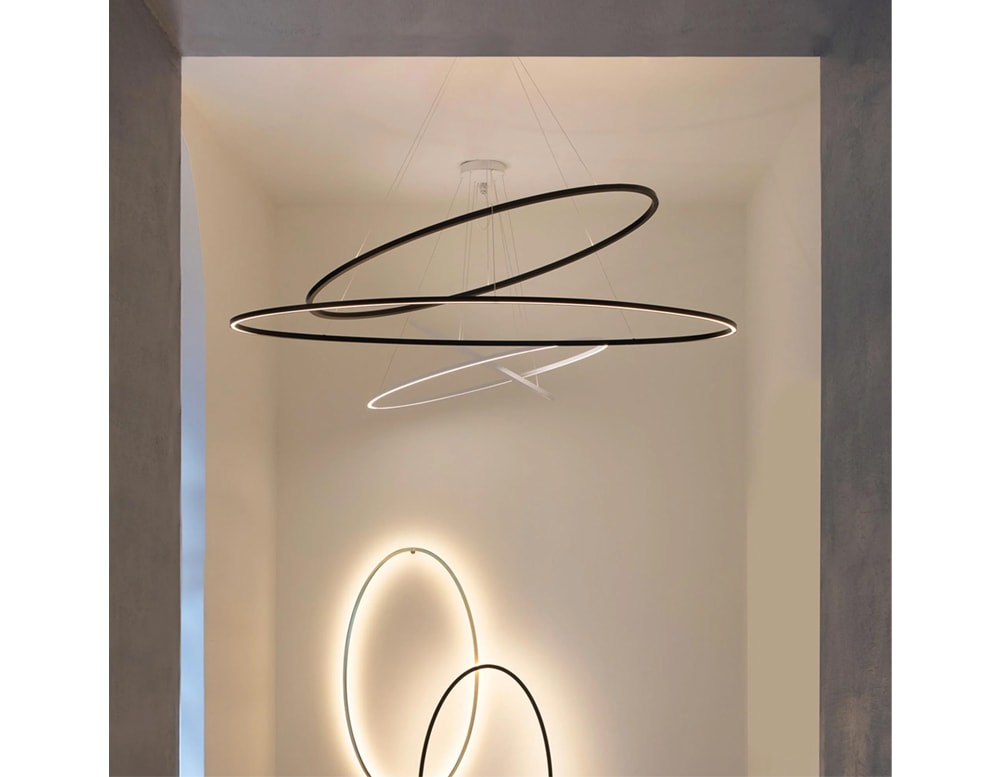 Hanging lamp with a metal base in the shape of rings on a white background.