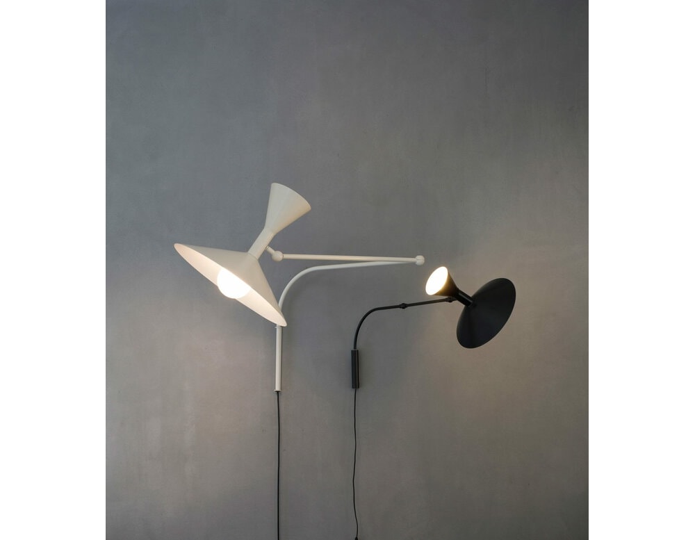 white metal lamp with a modifiable and striable elbow-shaped base in a room.