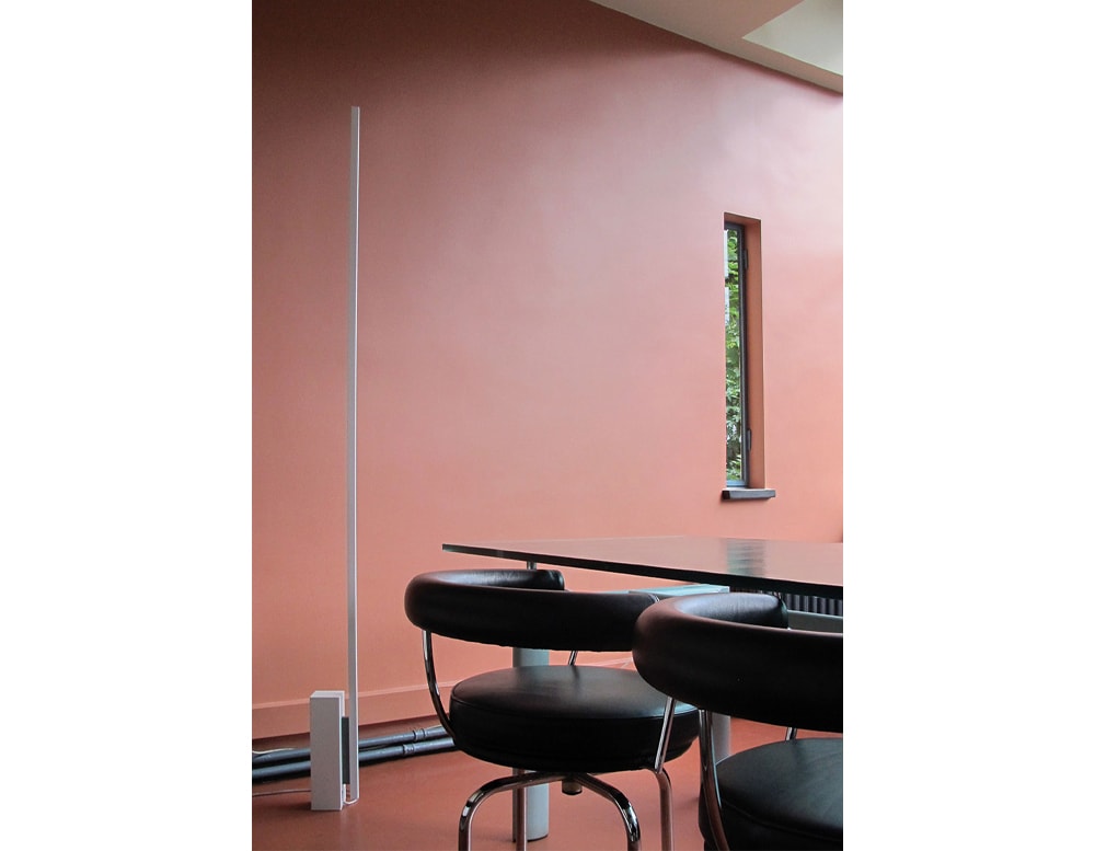 line-shaped floor lamp made of white painted metal in a living room