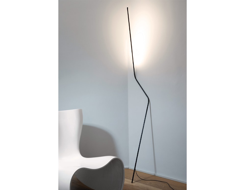 slim mobile lamp made of black metal with LED lighting in a room