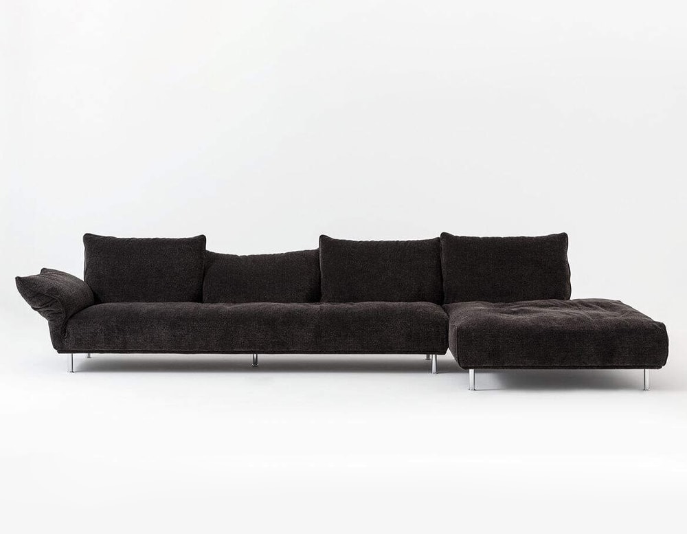 sofa made of soft fabric in a black tone with base on metal legs in a white background