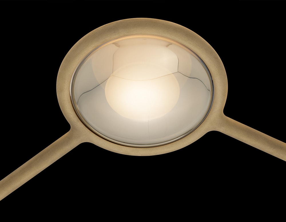 lamp made of metal with white LED lighting giving it a light golden tone in a black background