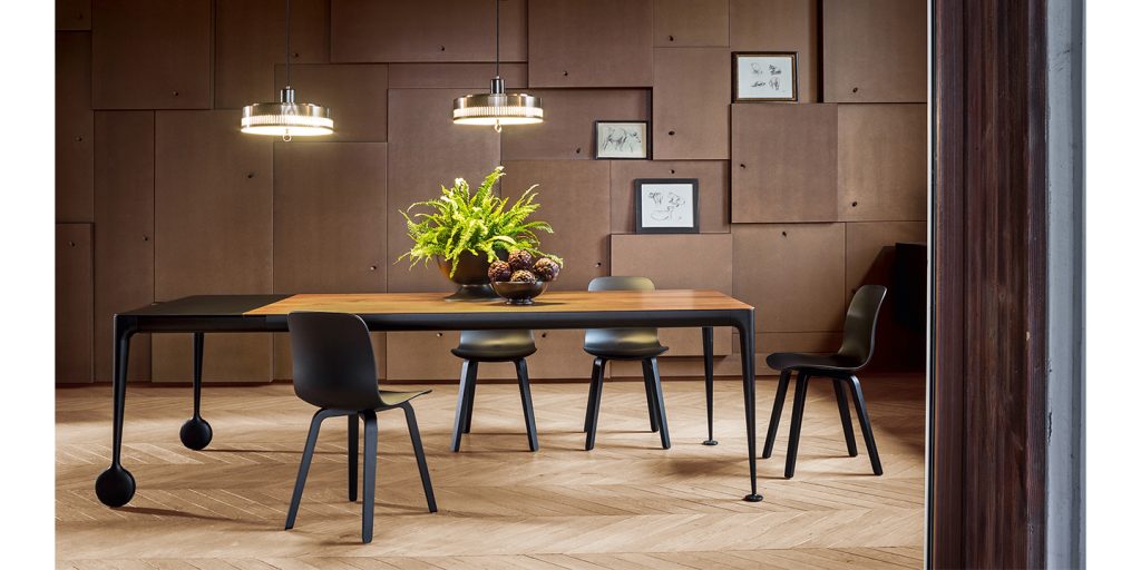 extendable and moveable table made of aluminum and orange wood in a dinign room