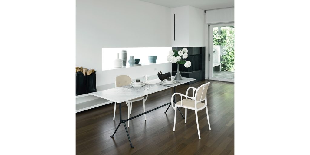 Stackable chairs made of aluminum and cream-colored fabric in a living room