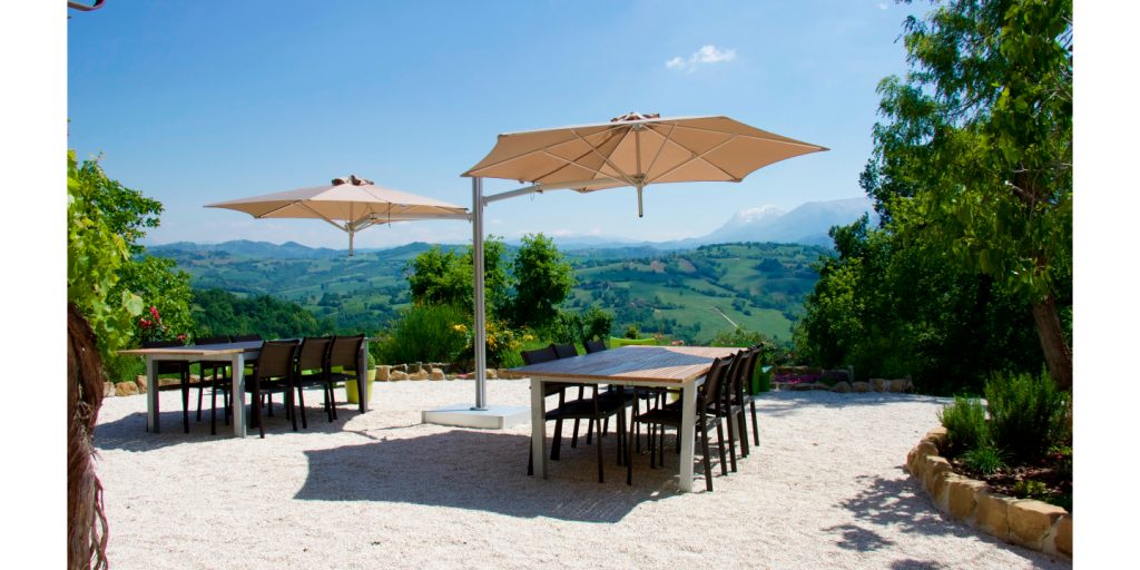 umbrellas with floating base in the shape of an aluminum arm and upholstered in fabric and its upper part in shades of orange