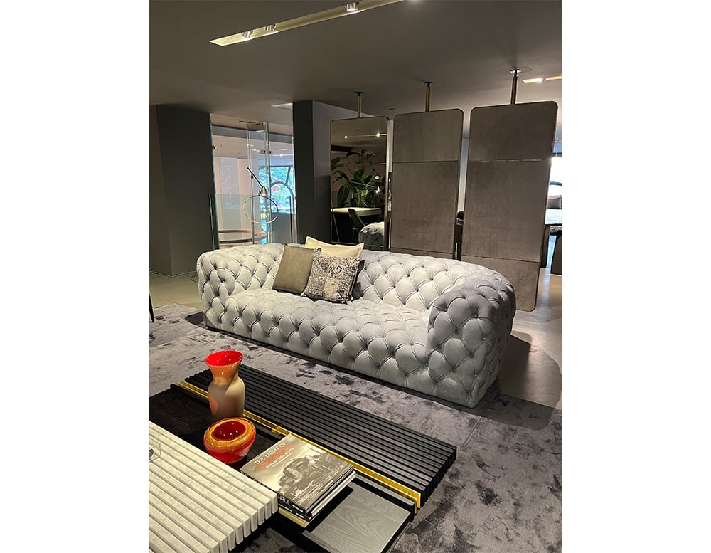 Sofa made of gray leather throughout its structure with linear and soft finishes in a living room
