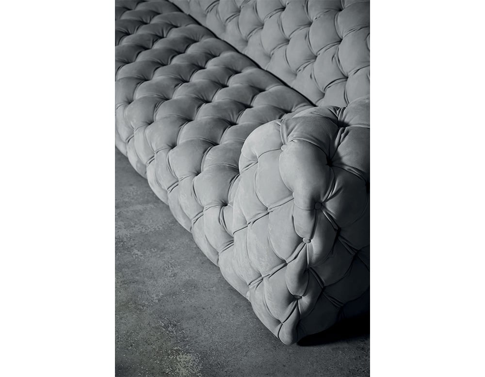 sofa made with gray leather finished in soft linear shapes throughout its structure