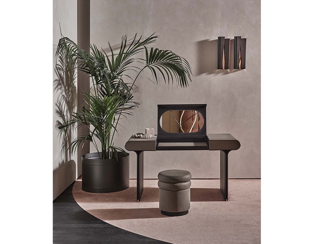 puff made of wood and polyurethane foam in a dark gray tone on a dressing table