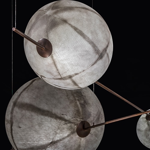 sphere shaped lamps made of fiberglass and with brass and metal stems in white and gold tones