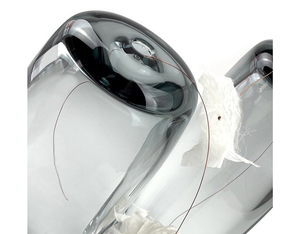 clear glass sculptures with dark base on a white background