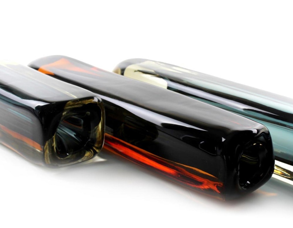 glass sculptures with a long square shape and a small bird on top.