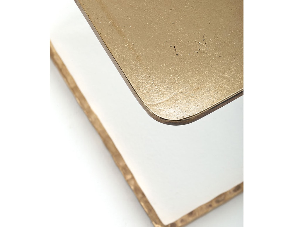 side table made of aluminum and bronze with gold tones on white background