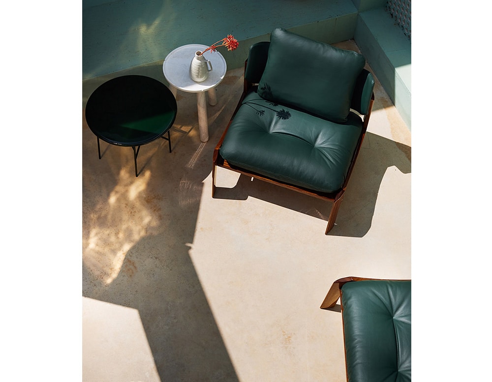 chairs made of light brown wood and dark green leather.