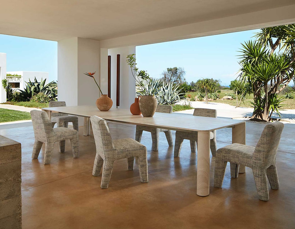 dining room chairs made with an aluminum base and upholstered with gray fabric.