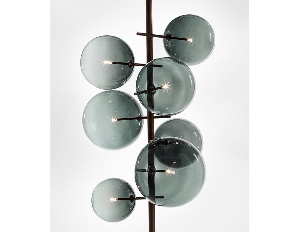 Floor lamp with 7 clear gray blown glass spheres on a white background