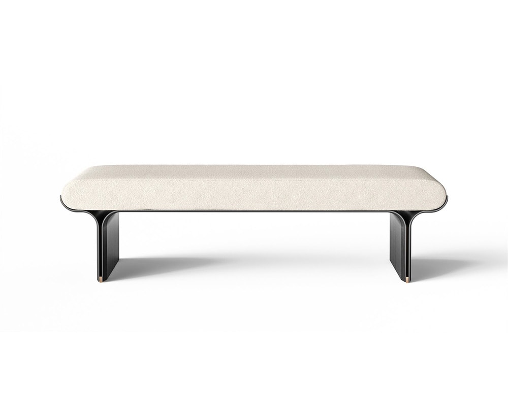 Bench with curved black stained ash base and bright brass details with a cushion covered by white fabric