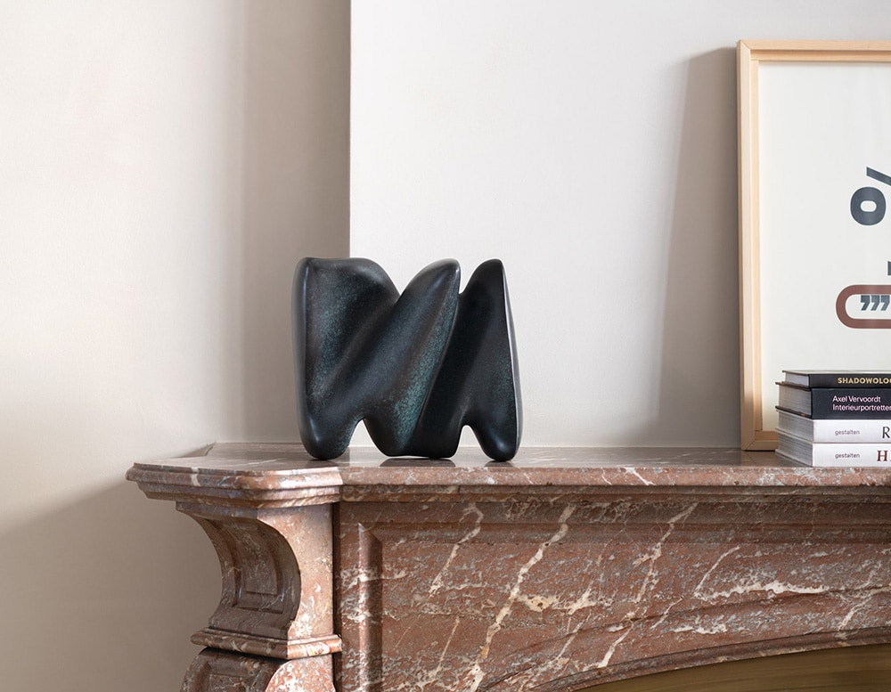 rounded bronze sculpture in all green and blue.