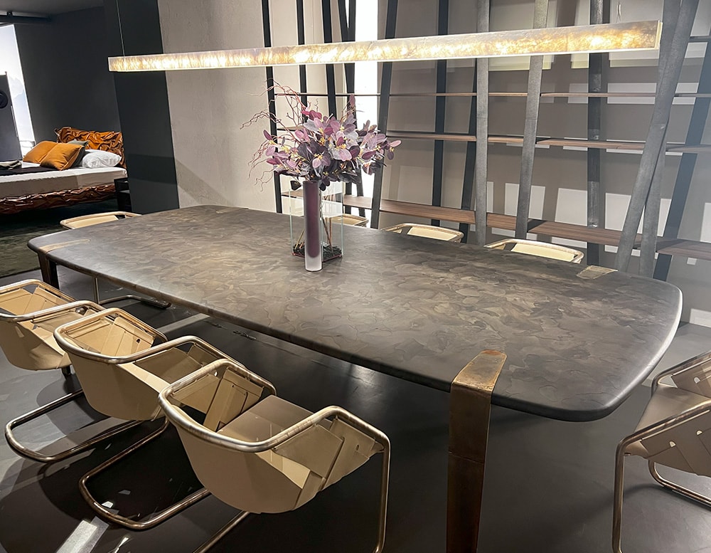 Dining table with walnut wood fusion top in a black micro-mosaic pattern, supported by slender bronze legs