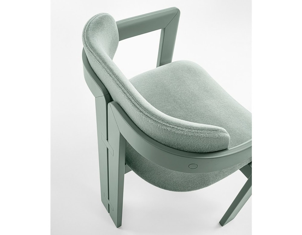 Curved ash wood chair upholstered in green leather on a white background.