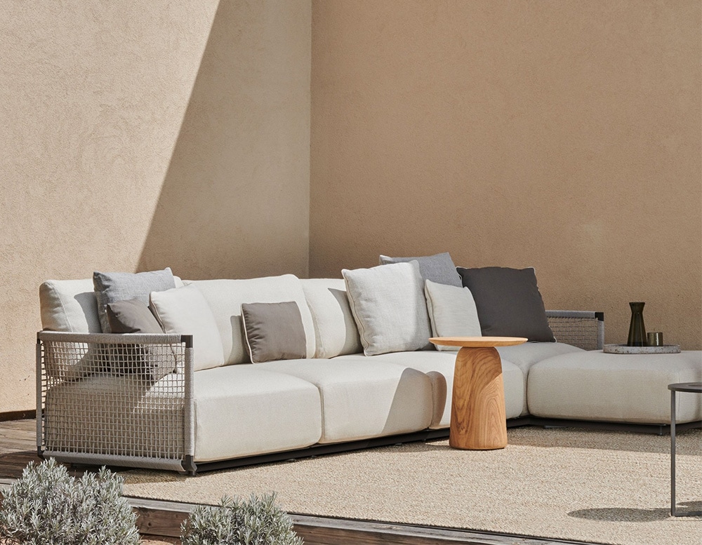 sofa made with a stainless steel base and upholstered in gray fabric