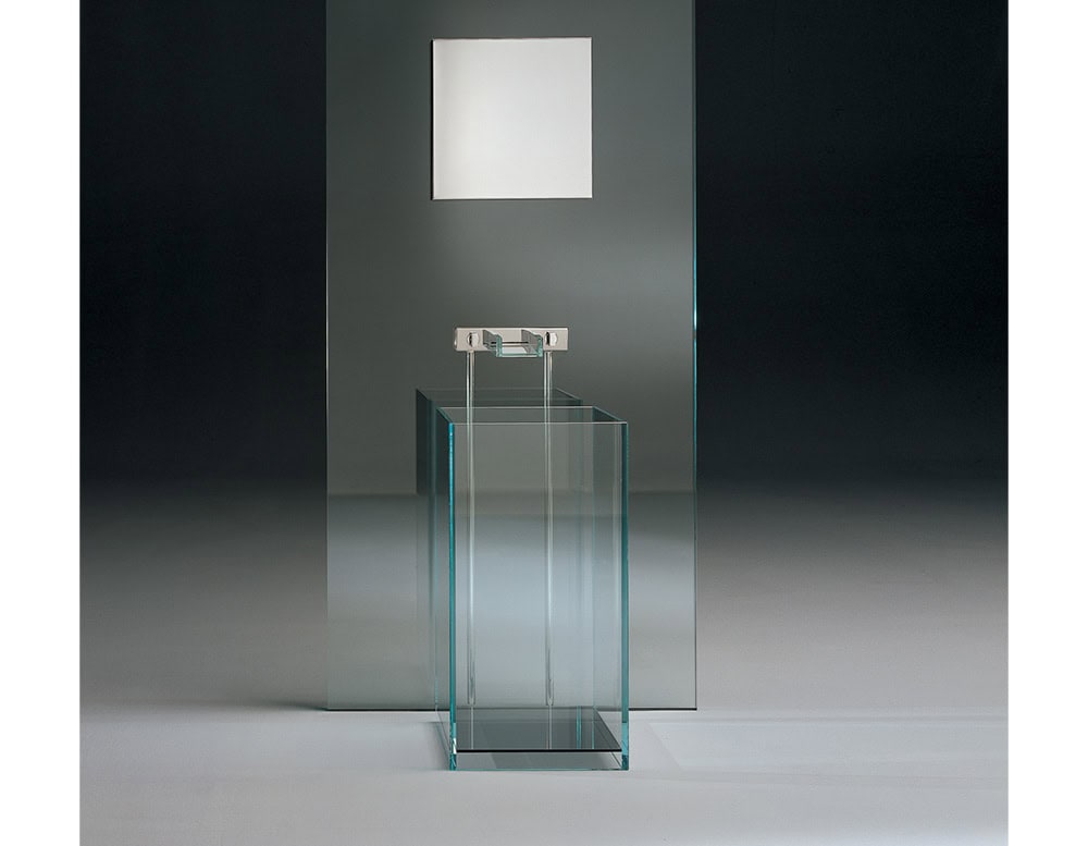 A modern Simplicity Bath design featuring a sleek glass structure with clean lines, illuminated by a soft, square wall light in a minimalist setting