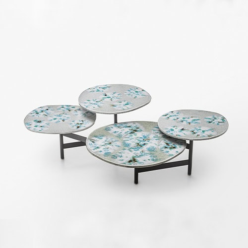 Side table with four tops made of steel in a natural lava stone color tone decorated with glass.
