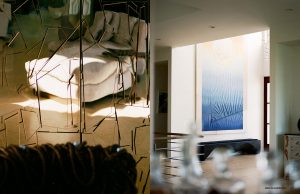 A contemporary interior with an abstract mirrored ceiling on one side and a serene minimalist space with a blue gradient painting on the other