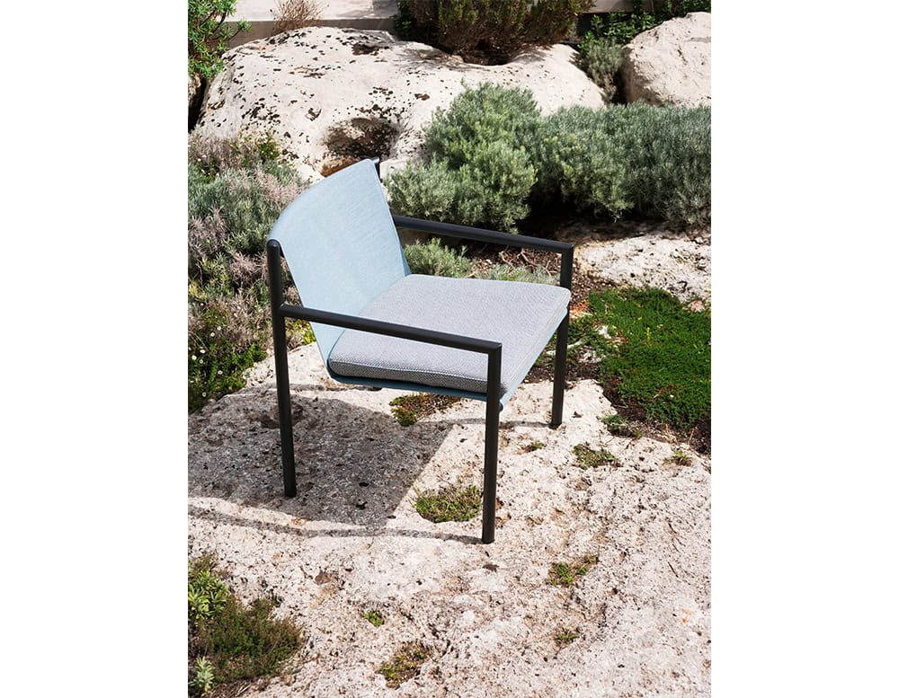 Contemporary outdoor armchair featuring a light frame with a soft-toned mesh back and cushioned seat, ideal for relaxing in open-air environments.