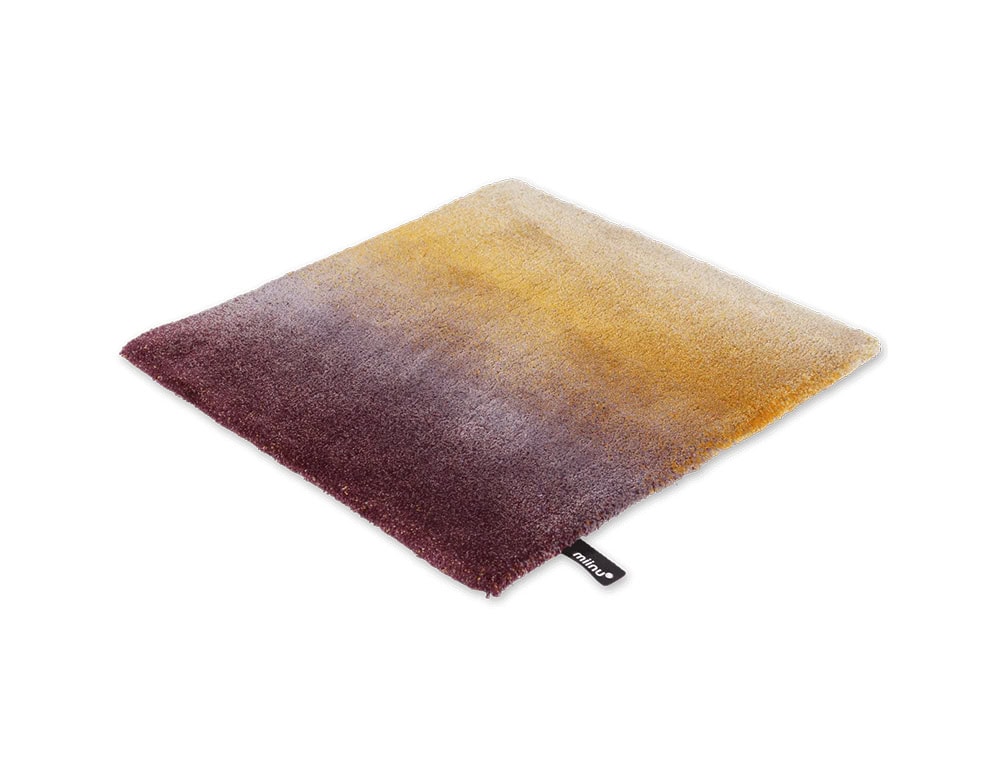 DeViant Rug displays a bold gradient that moves from a deep burgundy to warm amber and golden tones. This vibrant color transition adds rich visual warmth and a sense of artistic expression to any modern space.